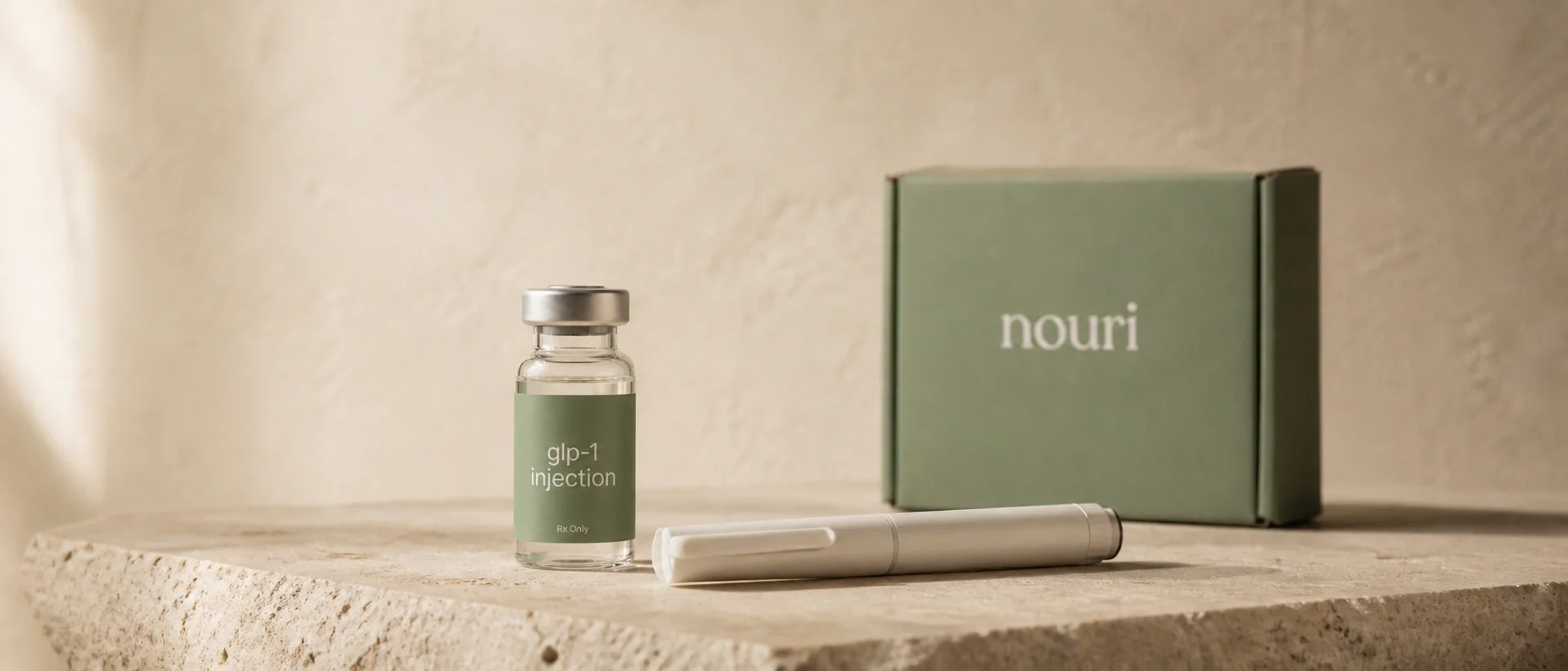 Nouri's compounded GLP-1 medication, dosing pen, and delivery box arranged on stone